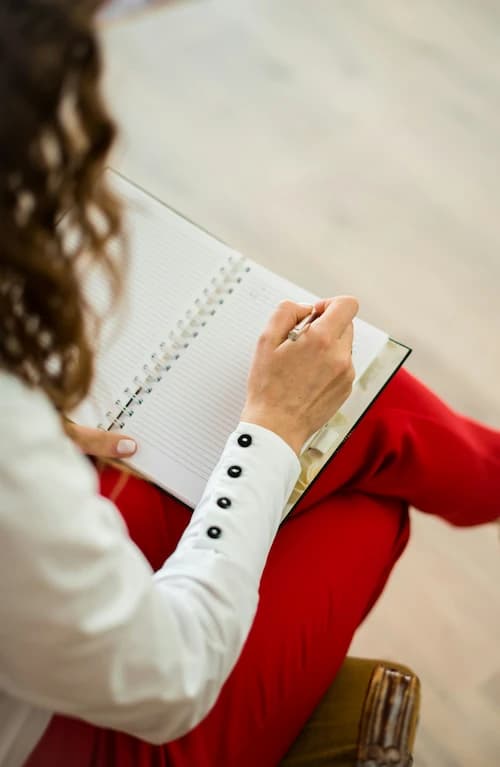 Person schreibt in einem Notizbuch